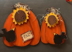 two pumpkins decorated with sunflowers are sitting on a table