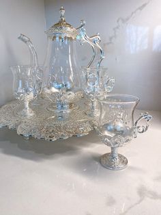 an ornate glass tea set on a white table