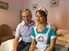 a man and woman sitting on top of a bed