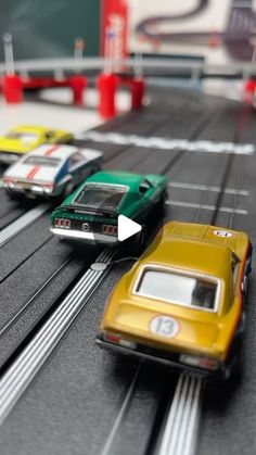 several toy cars on a track with one car moving