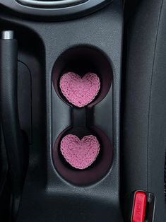 two heart shaped cups in the center console of a car