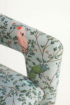 an upholstered chair with a bird on it