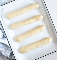 four doughsticks sitting on top of a white tray