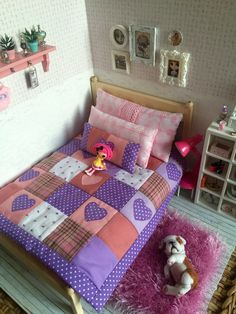 a dollhouse bedroom with pink and purple bedspread, teddy bear and other furniture