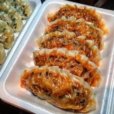 there are many different types of food in the trays on the table, including dumplings and noodles