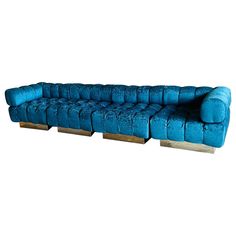 a blue couch sitting on top of a wooden block