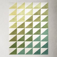 a green and white rug with triangles on it