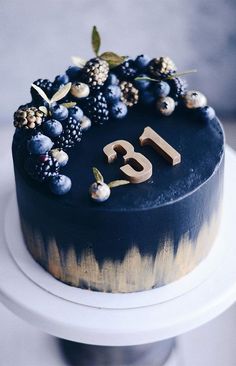 a cake with blueberries and berries on top is decorated with the number twenty five