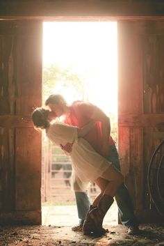 a man and woman are kissing in an open doorway with sunlight streaming through the door