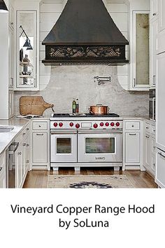 a stove top oven sitting inside of a kitchen next to white cupboards and drawers