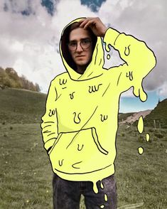 a man in a yellow hoodie is holding his hands on his head