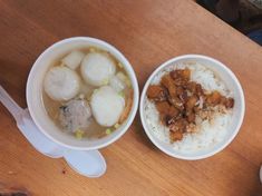 two bowls filled with food sitting on top of a wooden table