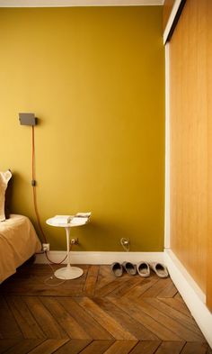 a bedroom with yellow walls and wooden floors