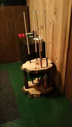 a wooden table with candles on it in front of a wood paneled wall and green floor