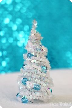 a small white christmas tree sitting on top of a table