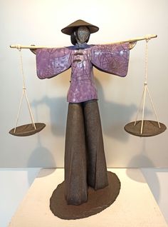 a statue of a person holding two balance scales