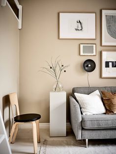 a living room filled with furniture and pictures on the wall above it's couch