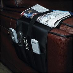 a piece of luggage sitting on top of a floor next to a newspaper and cell phone