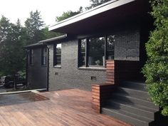 a black house with wooden decking and stairs