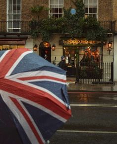 an open umbrella with the british flag on it is in front of a storefront