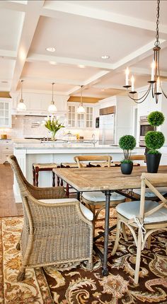 a dining room table and chairs in front of an open kitchen