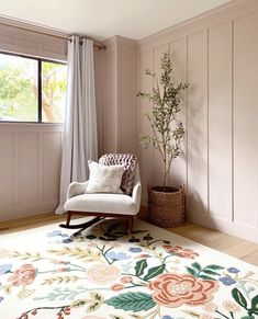 a living room with a chair, rug and window