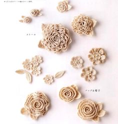 crocheted flowers and leaves are arranged on a white surface with japanese characters in the background