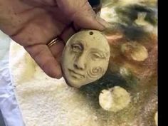 a person holding a stone with a face on it