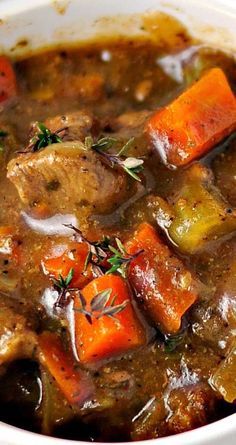 a white bowl filled with stew and carrots