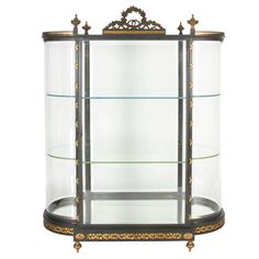 an ornate display case with glass shelves and gold trimmings on the bottom shelf