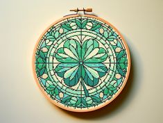 a cross - stitch pattern is displayed on a wall hanging with a wooden hoop frame