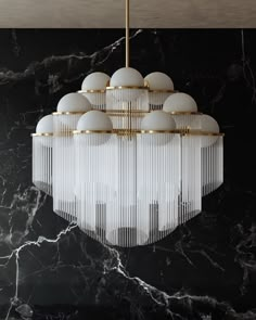 a chandelier hanging from the ceiling in a room with marble walls and flooring