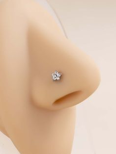 a close up view of the back of a mannequin's head with two small diamond studs on it