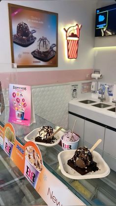 three scoops of ice cream sit on display in a store's kitchen area