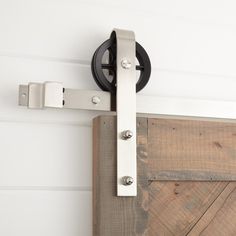 a close up of a sliding door with metal hardware on the side and wood planks behind it