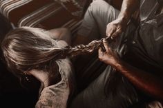 a woman is braiding another person's hair