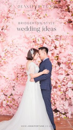 a bride and groom standing in front of a pink floral wall at the end of their wedding day