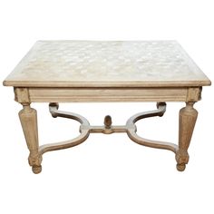 a wooden table with an intricate design on it's top and legs, against a white background