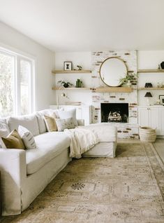 a living room filled with furniture and a fire place in front of a brick fireplace