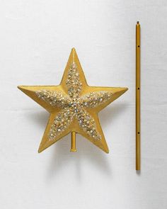 a golden star shaped object next to a pencil