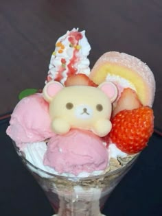 an ice cream sundae with strawberries, strawberrys and a teddy bear on top