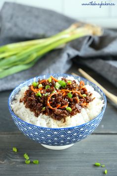 an easy korean beef rice bowl with chopsticks and green onions on the side