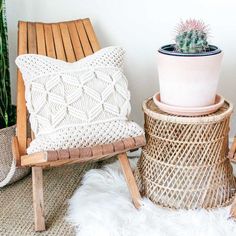 a chair, potted plant and pillow on a rug