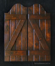 a wooden gate with two sliding doors on it's sides and the top panel is made out of wood