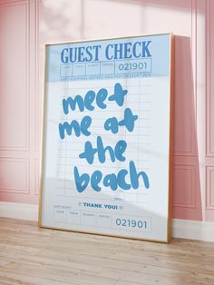 a sign that says meet me at the beach next to a pink wall and wooden floor