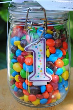 a jar filled with lots of candy and a number one tag hanging from the top