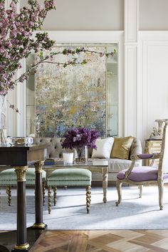 a living room filled with lots of furniture and flowers in vases on the table