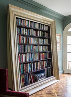 a large book shelf filled with lots of books in front of a doorway to another room