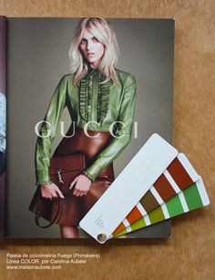 an open magazine with a woman's green blouse and purse