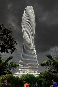 people standing in front of a tall building with a spiral design on it's side